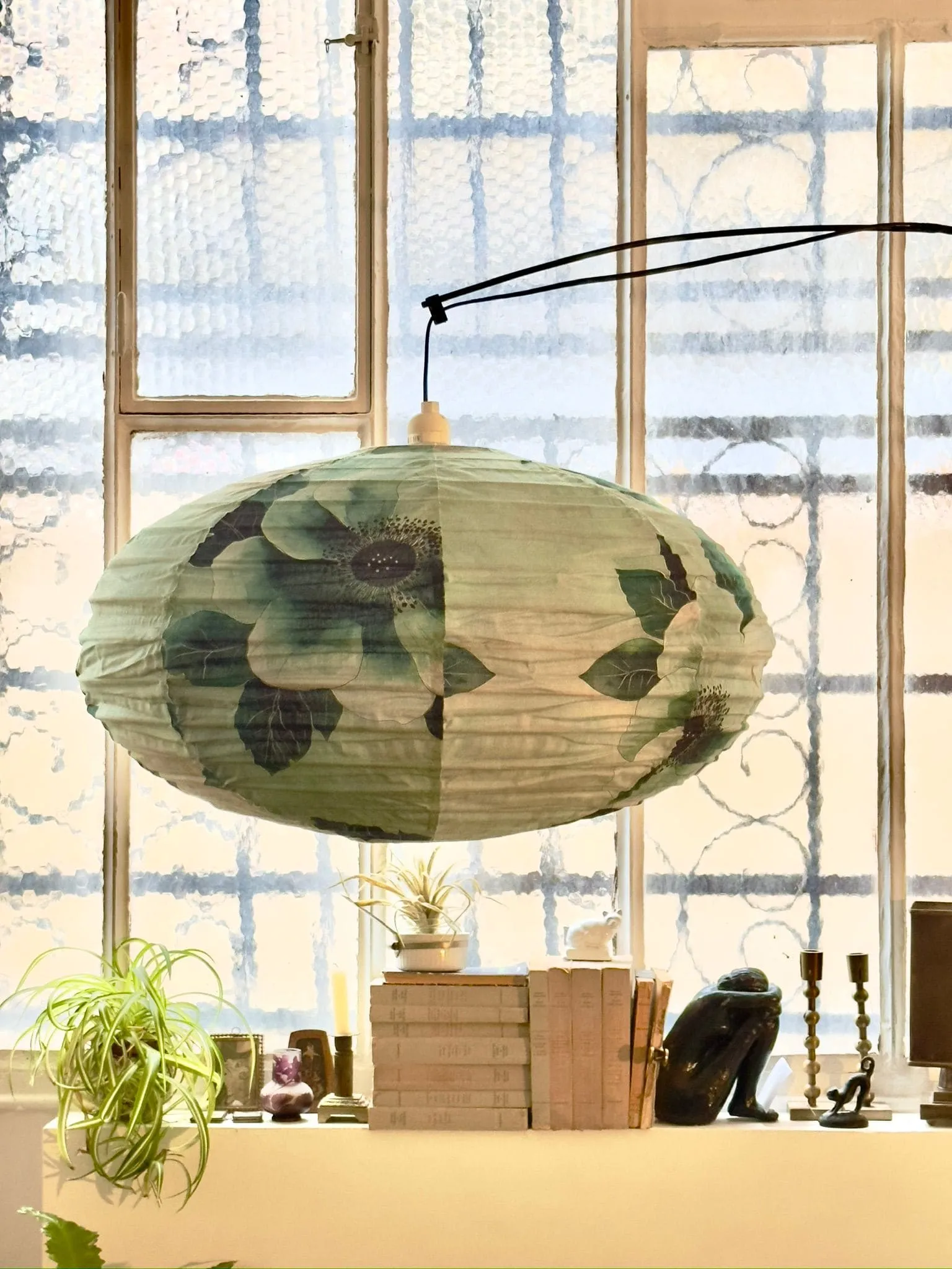 suspension canapé bleu et vert toile et papier peint dans showroom décoration Paris Belleville